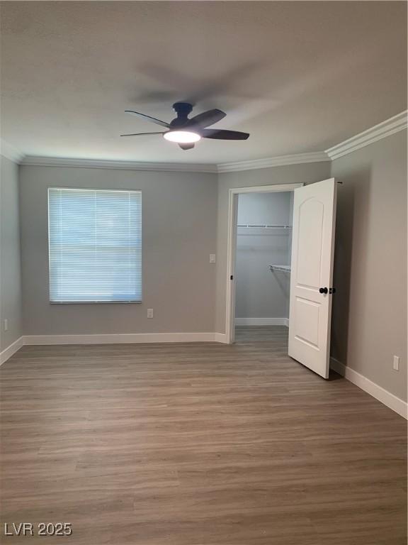8101 W Flamingo Rd Unit 1102, Las Vegas, NV 89147 - unfurnished bedroom with ornamental molding, wood finished floors, a ceiling fan, and a closet
