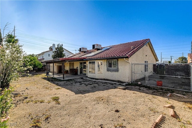 8517 Soneto Ln, Las Vegas, NV 89117 - back of property with a patio, roof mounted solar panels, a gate, a tiled roof, and stucco siding