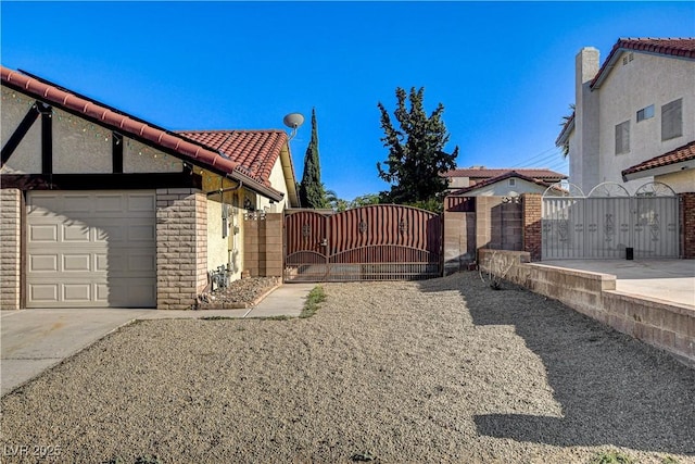 8517 Soneto Ln, Las Vegas, NV 89117 - view of property exterior with a gate, a tiled roof, stone siding, concrete driveway, and a garage