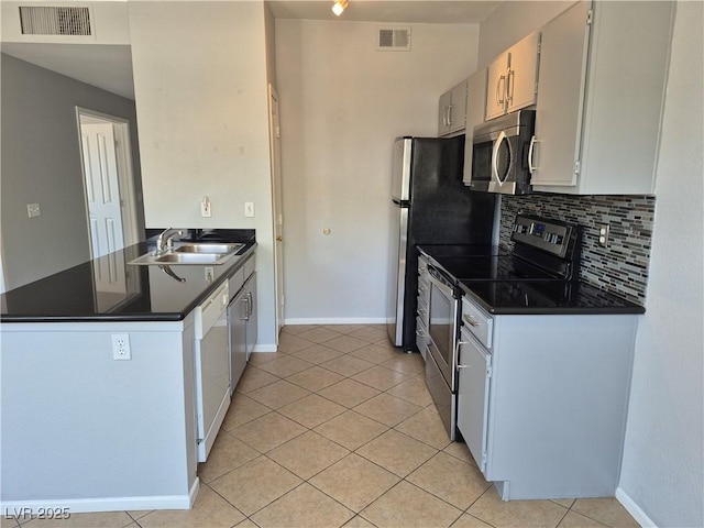 2900 Sunridge Heights Pkwy Unit 418, Henderson, NV 89052 - kitchen with appliances with stainless steel finishes, dark countertops, light tile patterned flooring, decorative backsplash, and a peninsula