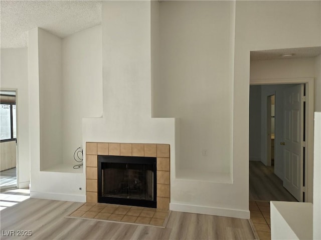 6636 Old Oxford Ave, Las Vegas, NV 89108 - detailed view of wood finished floors, a tiled fireplace, and a textured ceiling