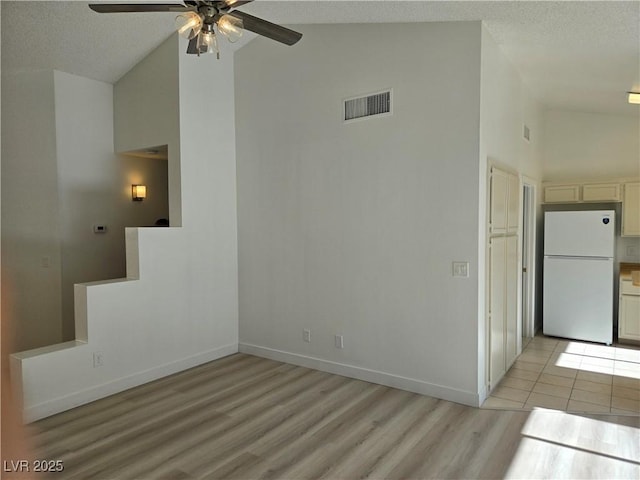 6636 Old Oxford Ave, Las Vegas, NV 89108 - empty room featuring high vaulted ceiling, ceiling fan, light wood finished floors, and a textured ceiling