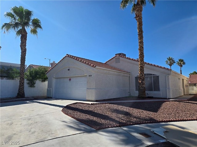 6636 Old Oxford Ave, Las Vegas, NV 89108 - view of front of property with an attached garage, driveway, a tile roof, and stucco siding