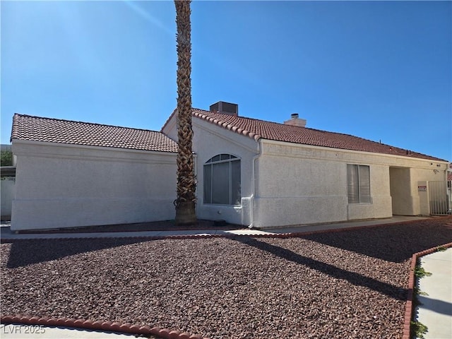 6636 Old Oxford Ave, Las Vegas, NV 89108 - rear view of house with a tiled roof, a chimney, and stucco siding