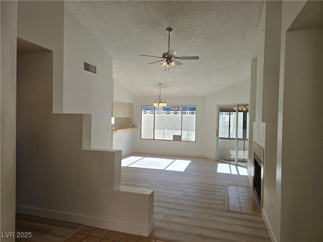6636 Old Oxford Ave, Las Vegas, NV 89108 - unfurnished living room with a textured ceiling, lofted ceiling, a ceiling fan, healthy amount of natural light, and wood finished floors