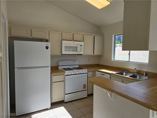 6636 Old Oxford Ave, Las Vegas, NV 89108 - kitchen with white appliances, lofted ceiling, a peninsula, light tile patterned floors, and light countertops