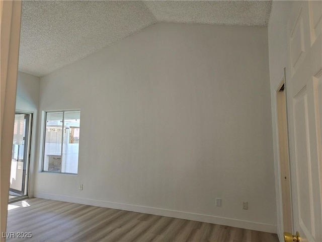 6636 Old Oxford Ave, Las Vegas, NV 89108 - unfurnished room featuring vaulted ceiling, light wood-type flooring, and a textured ceiling
