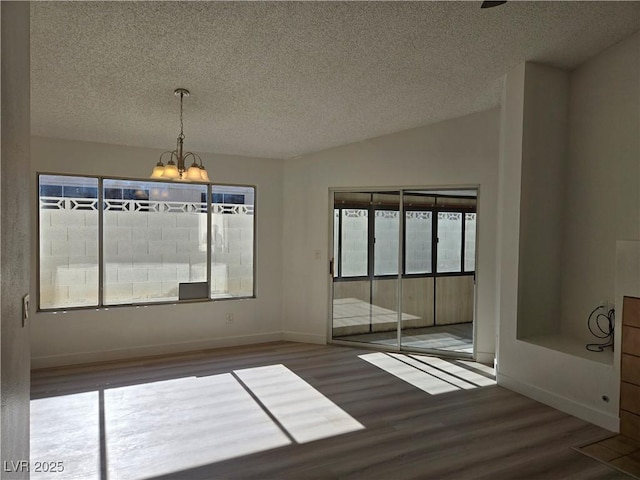 6636 Old Oxford Ave, Las Vegas, NV 89108 - unfurnished dining area with wood finished floors, a chandelier, a textured ceiling, and plenty of natural light