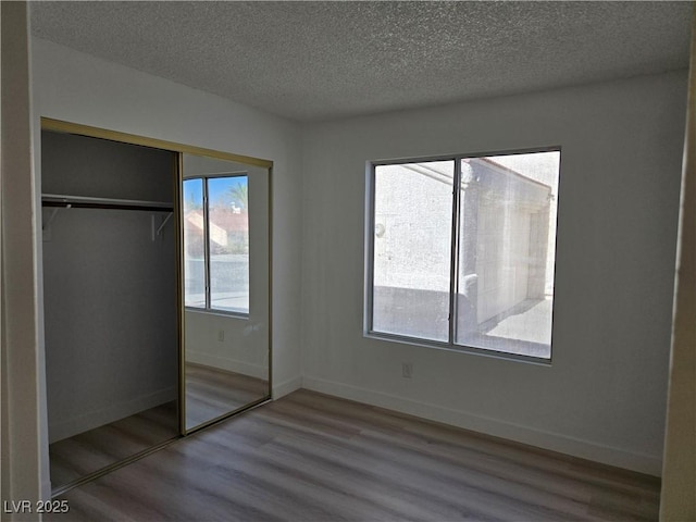 6636 Old Oxford Ave, Las Vegas, NV 89108 - unfurnished bedroom featuring wood finished floors, a textured ceiling, and a closet