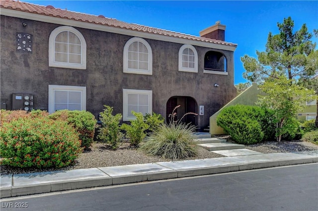 7950 W Flamingo Rd Unit 1042, Las Vegas, NV 89147 - view of front facade with a chimney, stucco siding, and a tile roof