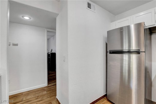 7950 W Flamingo Rd Unit 1042, Las Vegas, NV 89147 - kitchen featuring freestanding refrigerator, white cabinetry, and light wood-style floors