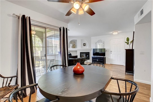 7950 W Flamingo Rd Unit 1042, Las Vegas, NV 89147 - dining area featuring ceiling fan, a glass covered fireplace, and light wood-type flooring