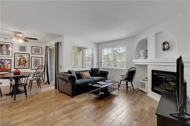 7950 W Flamingo Rd Unit 1042, Las Vegas, NV 89147 - living area featuring light wood finished floors, a ceiling fan, and a glass covered fireplace