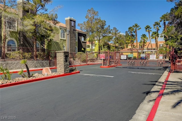 7950 W Flamingo Rd Unit 1042, Las Vegas, NV 89147 - view of asphalt road featuring curbs, a gate, and a gated entry