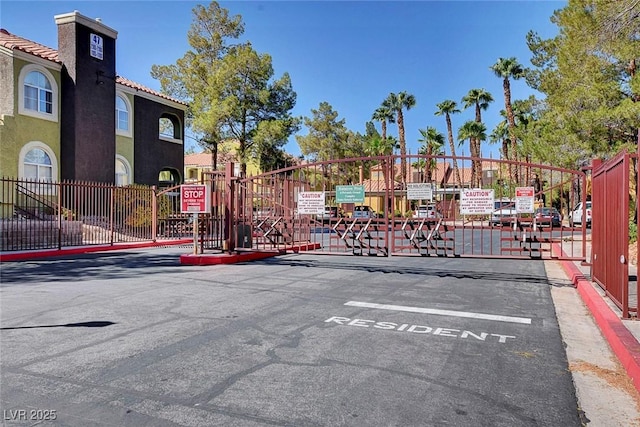7950 W Flamingo Rd Unit 1042, Las Vegas, NV 89147 - view of asphalt road featuring a gated entry, a gate, and curbs