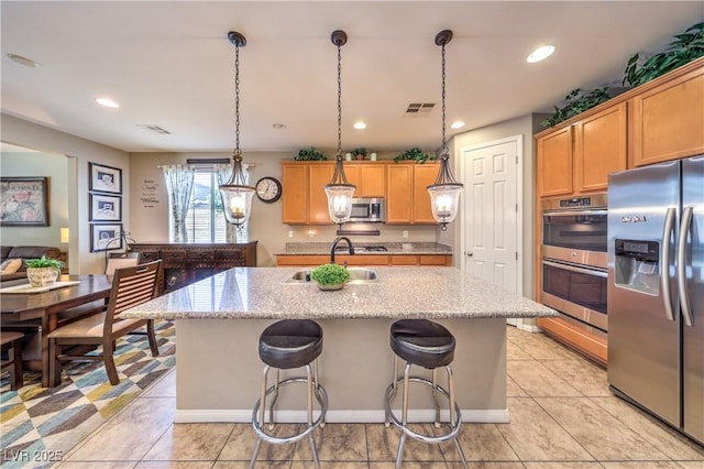 10961 Winter Rise St, Las Vegas, NV 89141 - kitchen featuring stainless steel appliances, an island with sink, a kitchen breakfast bar, light stone counters, and recessed lighting
