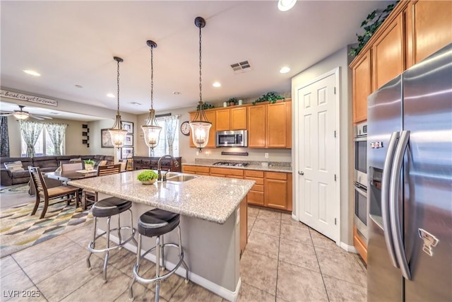 10961 Winter Rise St, Las Vegas, NV 89141 - kitchen featuring stainless steel appliances, light tile patterned flooring, a center island with sink, light stone countertops, and recessed lighting