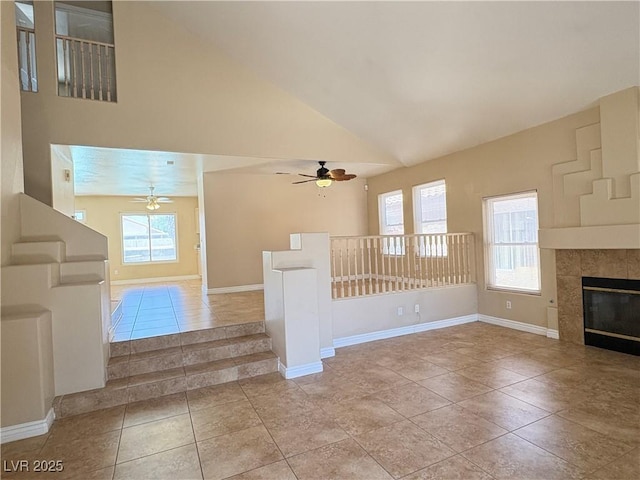 3679 Funston Way, Las Vegas, NV 89129 - unfurnished living room featuring a ceiling fan, light tile patterned flooring, high vaulted ceiling, and a tile fireplace