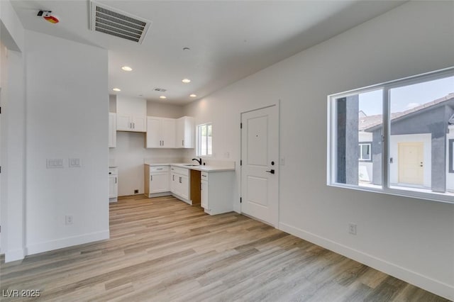 383 N 16th St, Las Vegas, NV 89101 - kitchen featuring white cabinets, light wood-style flooring, light countertops, and recessed lighting
