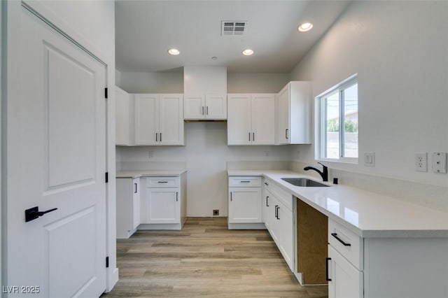 383 N 16th St, Las Vegas, NV 89101 - kitchen with light wood finished floors, white cabinetry, recessed lighting, and light countertops