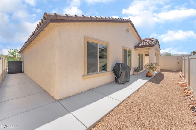 518 Descubir Ave, North Las Vegas, NV 89081 - rear view of property with stucco siding, a tile roof, a patio area, a fenced backyard, and a gate