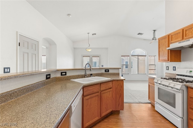 89 Day Trade St Unit 1, Henderson, NV 89074 - kitchen featuring white appliances, under cabinet range hood, vaulted ceiling, plenty of natural light, and light wood-style floors