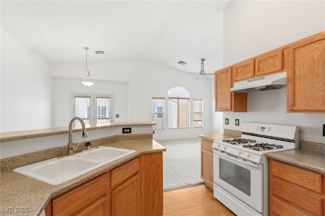 89 Day Trade St Unit 1, Henderson, NV 89074 - kitchen with white range with gas stovetop, under cabinet range hood, lofted ceiling, healthy amount of natural light, and light countertops
