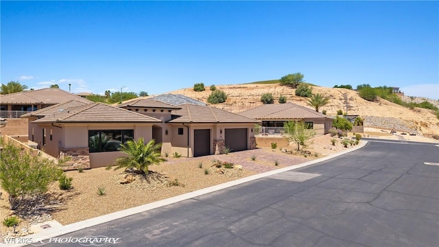 479 Apogee Crst, Mesquite, NV 89027 - view of front of house featuring a garage, stucco siding, a tiled roof, and stone siding