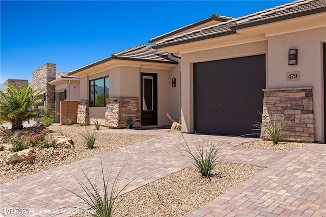 479 Apogee Crst, Mesquite, NV 89027 - view of front of home featuring decorative driveway, stone siding, a garage, stucco siding, and a tile roof