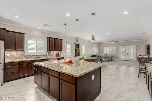 1304 Fantastic Ct, North Las Vegas, NV 89081 - kitchen featuring a center island, healthy amount of natural light, recessed lighting, billiards, and light marble finish flooring