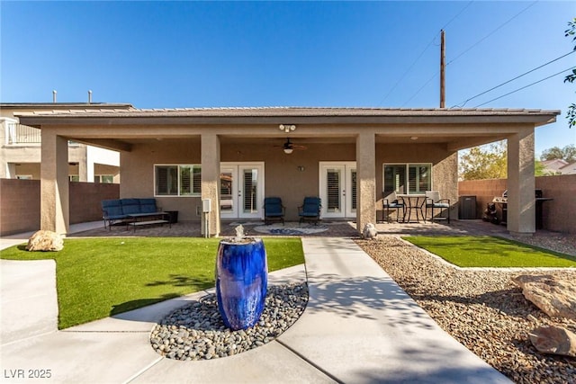 1304 Fantastic Ct, North Las Vegas, NV 89081 - back of property featuring french doors, stucco siding, a ceiling fan, an outdoor hangout area, and a patio area