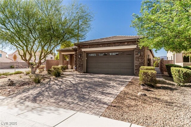 1304 Fantastic Ct, North Las Vegas, NV 89081 - view of front of property with stone siding, decorative driveway, a garage, stucco siding, and a gate