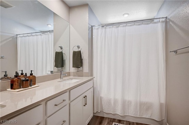 3358 Via Strada St, Henderson, NV 89044 - bathroom featuring double vanity, wood finished floors, and shower / bathtub combination with curtain