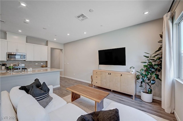 3358 Via Strada St, Henderson, NV 89044 - living room featuring light wood-style floors and recessed lighting