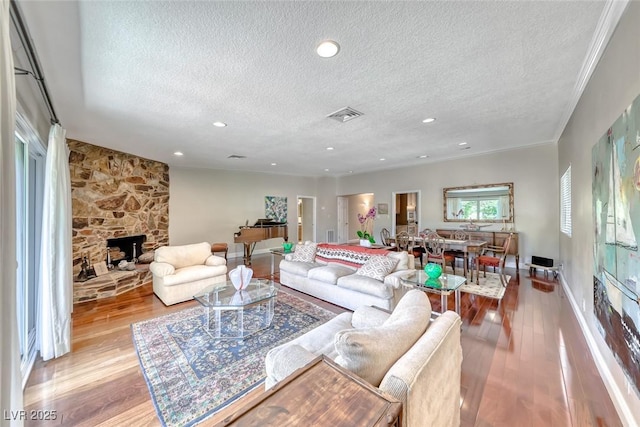 2101 Plaza Del Fuentes, Las Vegas, NV 89102 - living area featuring a textured ceiling, wood finished floors, a stone fireplace, and recessed lighting