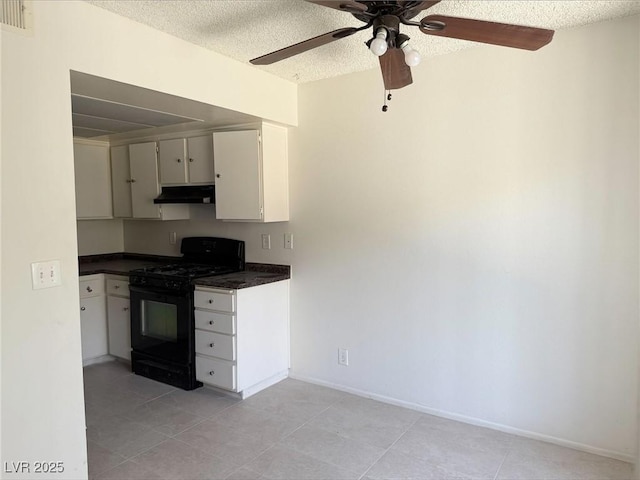 4338 Caliente St Unit 12, Las Vegas, NV 89119 - kitchen featuring black gas range, under cabinet range hood, dark countertops, light tile patterned floors, and a ceiling fan