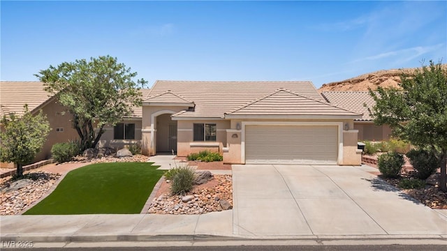 871 Falcon Glenn Dr, Mesquite, NV 89027 - ranch-style house featuring an attached garage, concrete driveway, stucco siding, a tiled roof, and a front yard