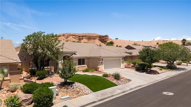 871 Falcon Glenn Dr, Mesquite, NV 89027 - view of front facade featuring driveway, a garage, stucco siding, a mountain view, and a tile roof
