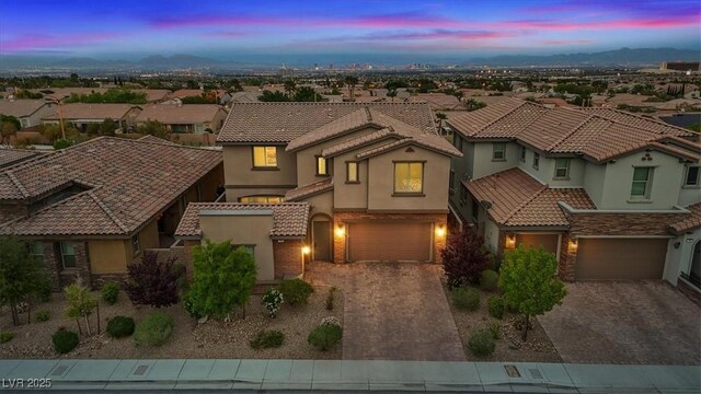 342 Molinetto St, Las Vegas, NV 89138 - mediterranean / spanish home featuring a tiled roof, an attached garage, stucco siding, driveway, and a residential view