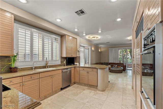 8215 Crow Valley Ln, Las Vegas, NV 89113 - kitchen with stainless steel appliances, a peninsula, crown molding, recessed lighting, and open floor plan