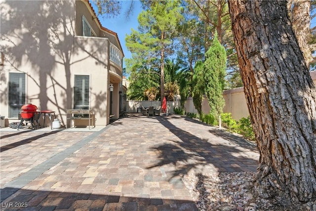 8215 Crow Valley Ln, Las Vegas, NV 89113 - view of home's exterior featuring stucco siding, a fenced backyard, a patio, and a balcony
