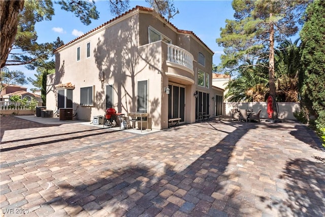 8215 Crow Valley Ln, Las Vegas, NV 89113 - back of property with a balcony, stucco siding, a tiled roof, and a patio