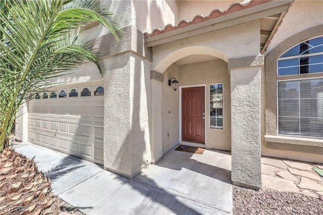 8712 Texas Bronco Ave, Las Vegas, NV 89129 - view of exterior entry with stucco siding, a garage, and a tile roof