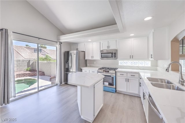 8712 Texas Bronco Ave, Las Vegas, NV 89129 - kitchen with appliances with stainless steel finishes, arched walkways, light wood-type flooring, white cabinets, and light stone counters