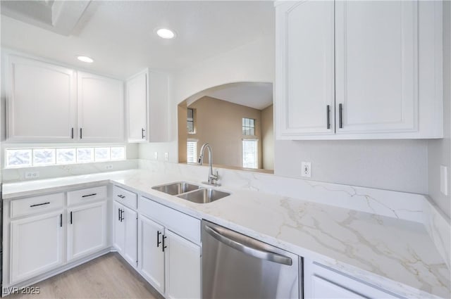 8712 Texas Bronco Ave, Las Vegas, NV 89129 - kitchen with dishwasher, arched walkways, white cabinets, light stone counters, and light wood finished floors