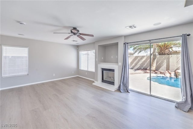 8712 Texas Bronco Ave, Las Vegas, NV 89129 - unfurnished living room with ceiling fan, wood finished floors, and a glass covered fireplace