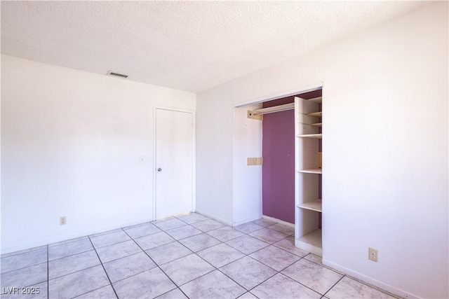 5673 Coaldale Pl, Las Vegas, NV 89110 - unfurnished bedroom featuring a textured ceiling, a closet, and light tile patterned flooring