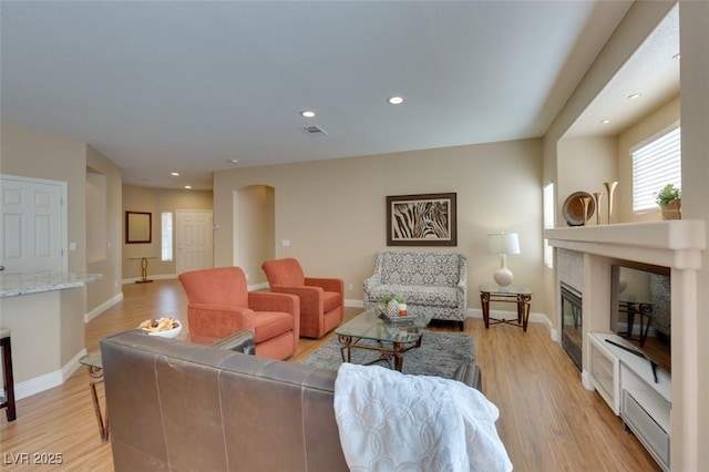 10243 Songsparrow Ct, Las Vegas, NV 89135 - living area with light wood finished floors, recessed lighting, a glass covered fireplace, and arched walkways