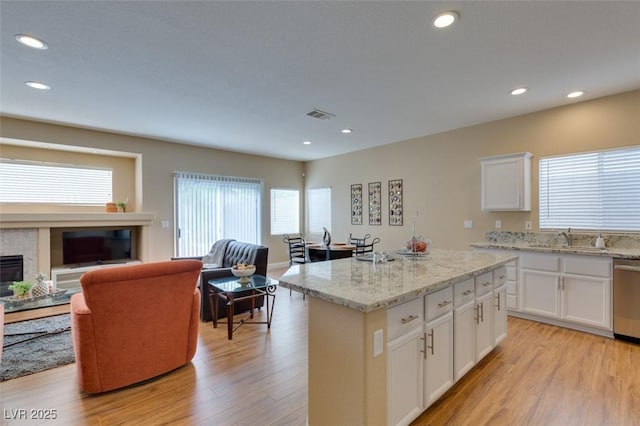 10243 Songsparrow Ct, Las Vegas, NV 89135 - kitchen with open floor plan, light wood finished floors, a center island, light stone counters, and recessed lighting