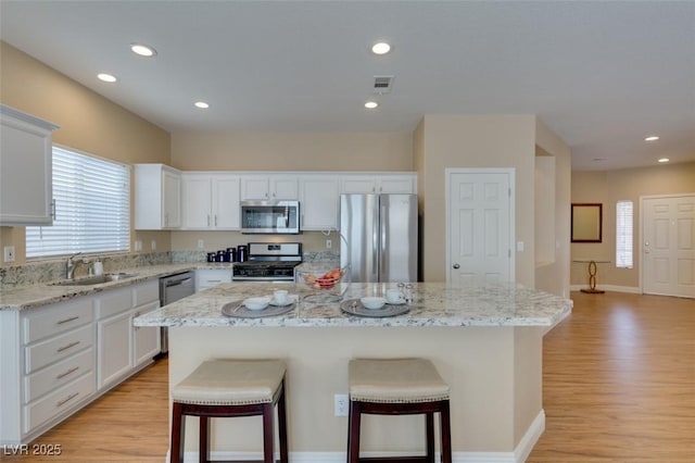 10243 Songsparrow Ct, Las Vegas, NV 89135 - kitchen featuring appliances with stainless steel finishes, healthy amount of natural light, a kitchen breakfast bar, light wood-type flooring, and recessed lighting